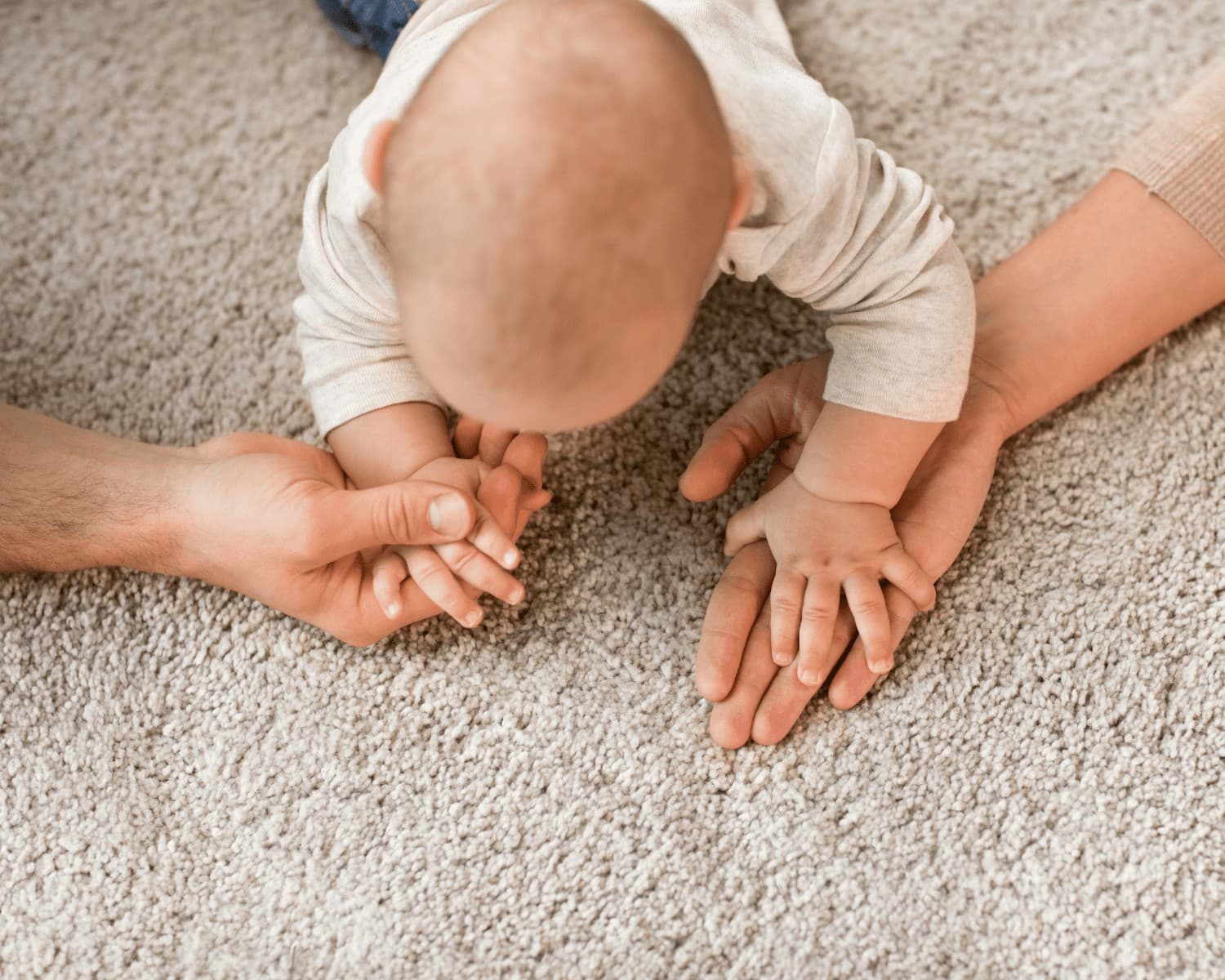 Baby crawling toward a parent's hands on freshly cleaned carpet in a Gallatin, TN home